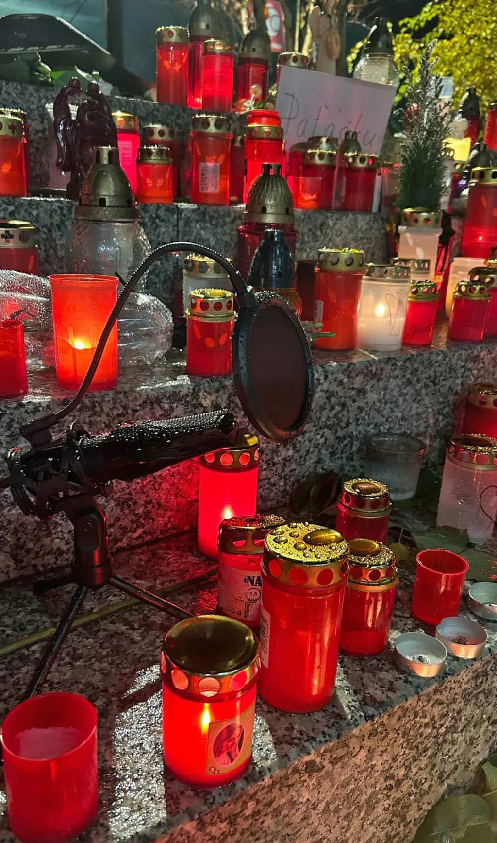 Na schodech před rádiem hoří svíčky. Uprostřed stojí mikrofon. Foto. IG
