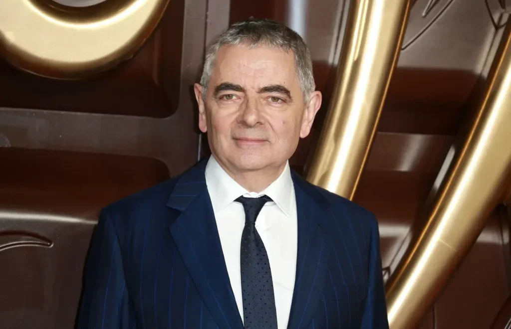 Britský herec Rowan Atkinson v modrém obleku na filmové premiéře