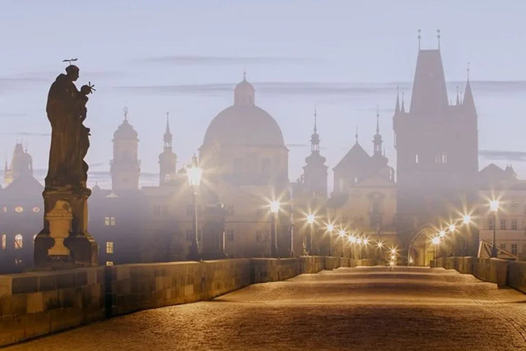Pohled za šera na rozsvícený Karlův most.