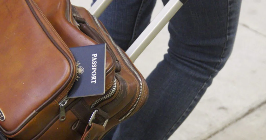 Cestující osoba s kufrem a pasem