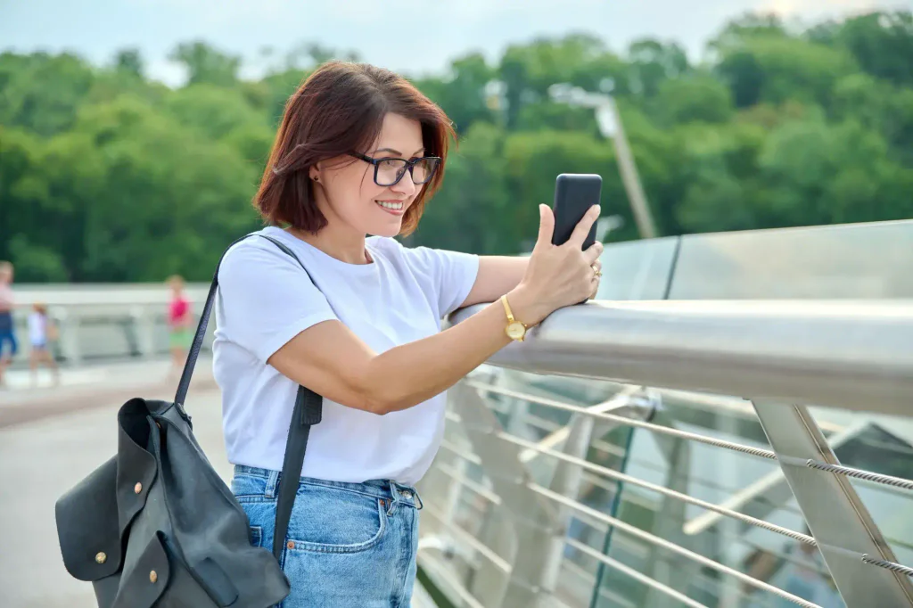 žena se dívá venku do mobilu