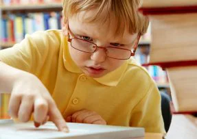 Chlapec s brýlemi sahá na klávesnici laptopu