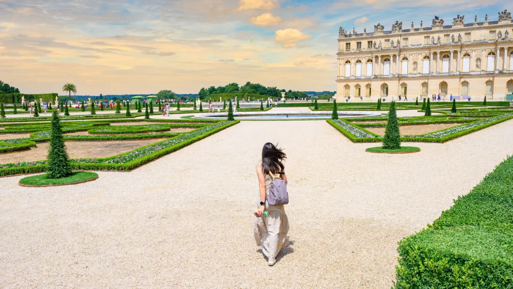 Mladá dívka na zahradách ve Versailles.