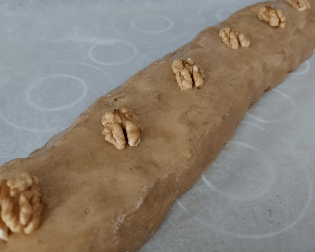  Zavinutý perník potřeme vajíčkem a můžeme zdobit kousky ořechů.