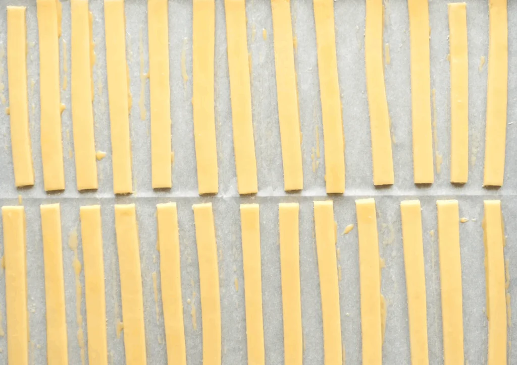 Těsto vyválíme a rozkrájíme na tenké tyčinky.