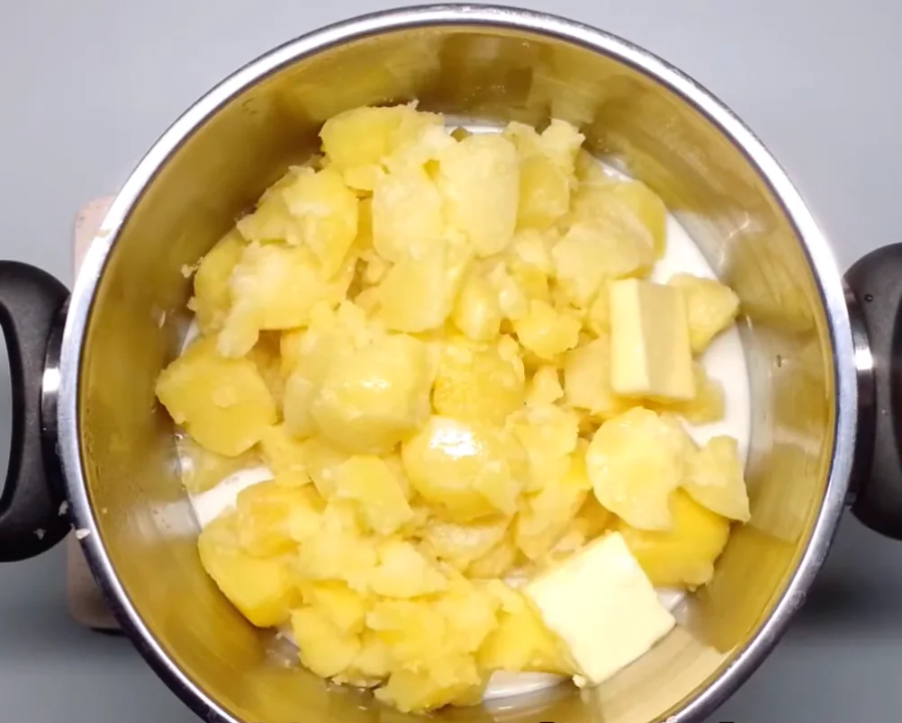 Uvařené brambory scedíme, přidáme máslo a horké mléko.