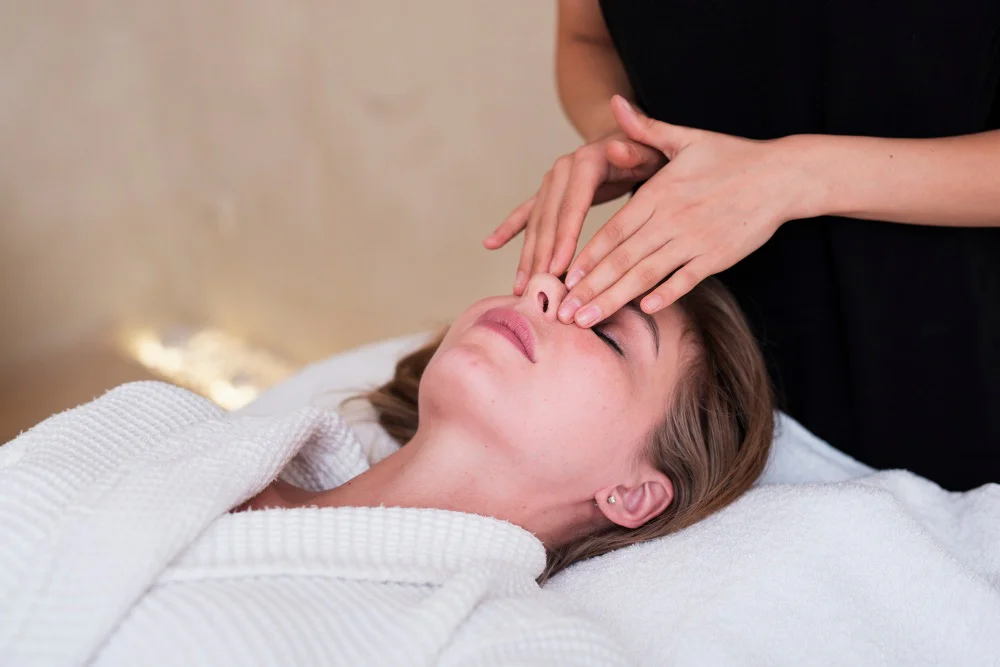 Mladá žena na masáži tlakových bodů na obličeji