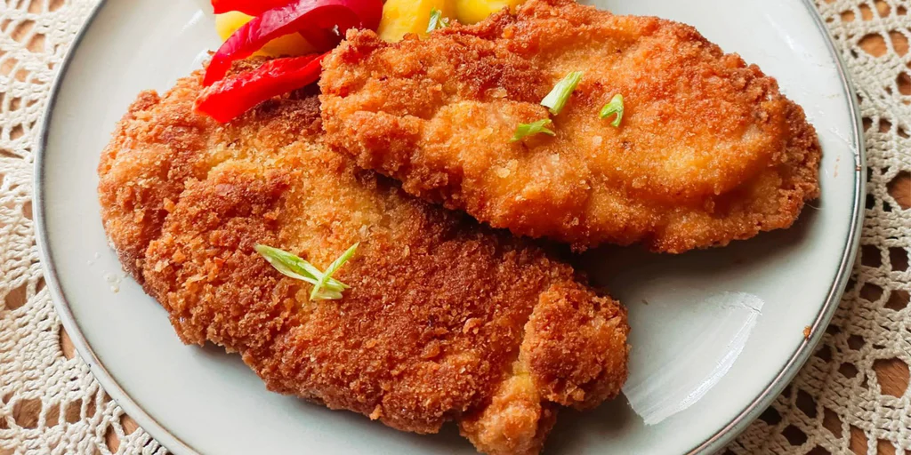 Obrázek receptu na Práskanec z pánve: klasický český řízek obalený v kouscích čerstvého pečiva