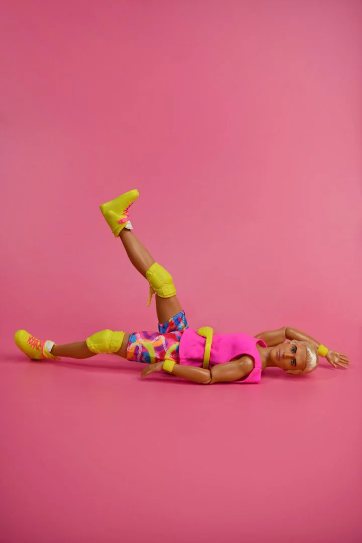 Doll in colorful athletic wear on pink background
