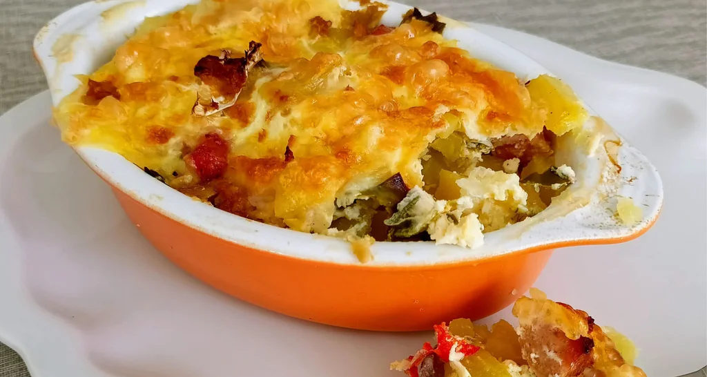 Obrázek receptu na zapečené brambory s uzeninou, pórkem a zakysanou smetanou.