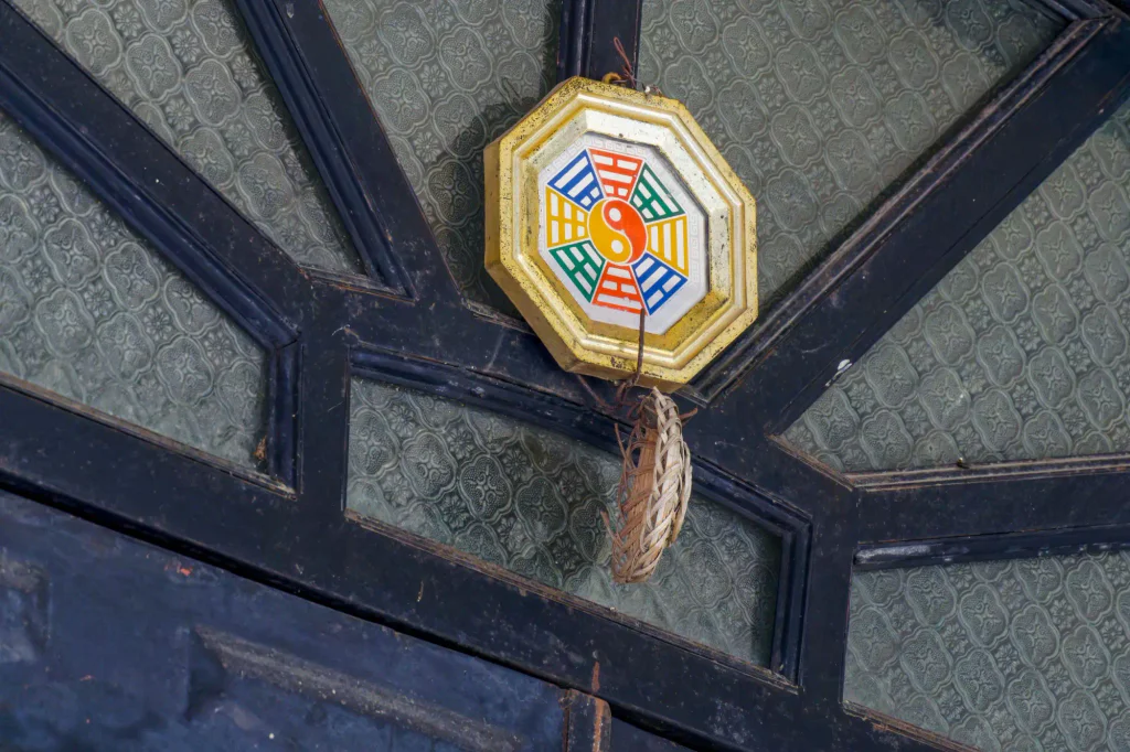 Zavěšené bagua zrcátko nad vchodovými dveřmi.