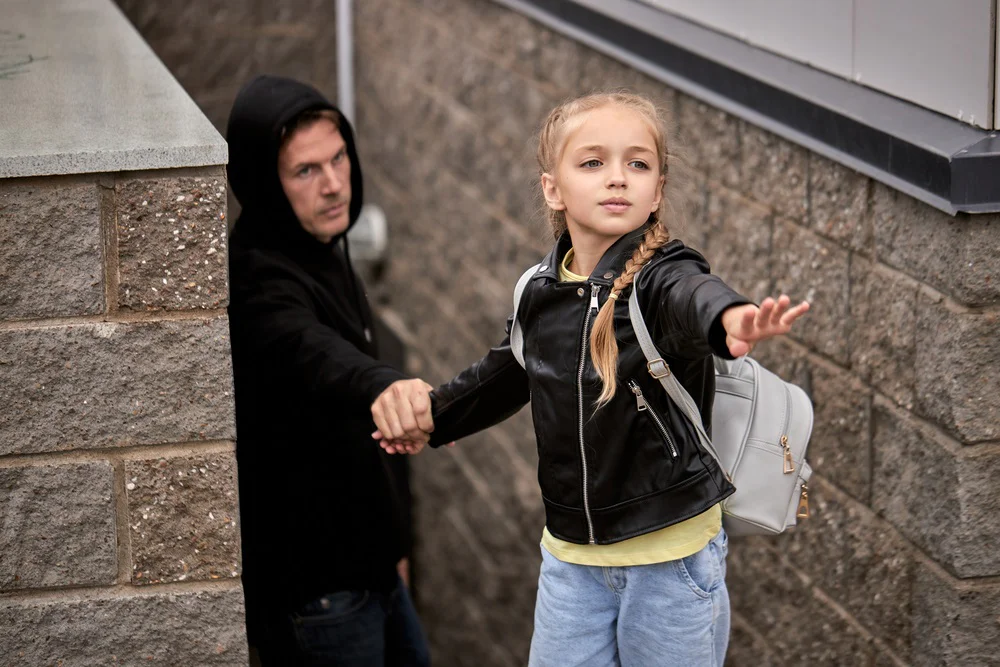 muž v černé mikině chce unést děvče