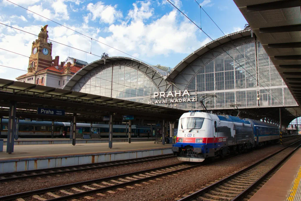 Vlak vyjíždějící ze stanice hlavního nádraží v Praze. Okolí je liduprázdné.