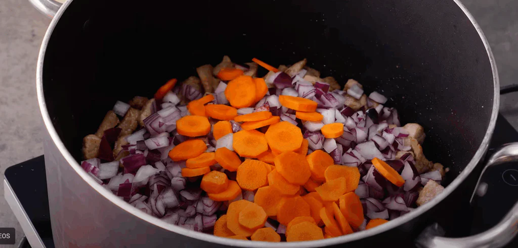 Přidáme drobně nakrájenou červenou cibuli a na kolečka nakrájenou mrkev