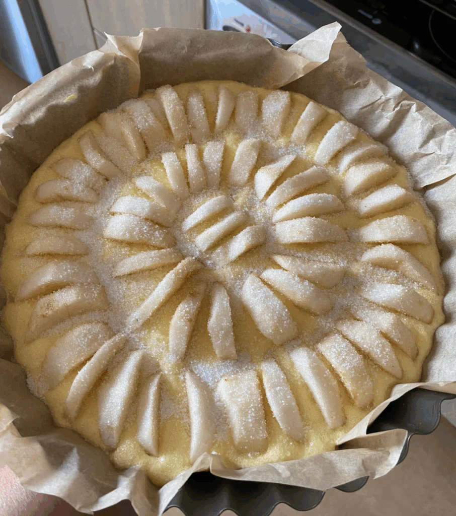 Poslední vrstvu jablek ukládáme na stojato, zalijeme zbytkem těsta a posypeme cukrem nebo ořechy.