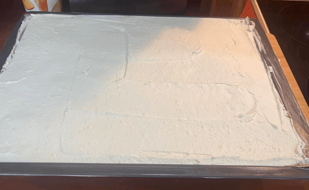 Na vychladlou ovocnou vrstvu navrstvíme vyšlehaný krém a necháme ztuhnout.