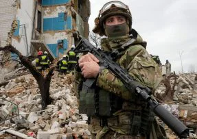 Ukrajinský voják u trosek domu