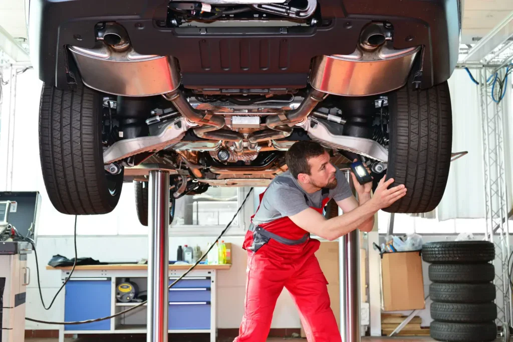 Technik kontroluje auto na zvedáku