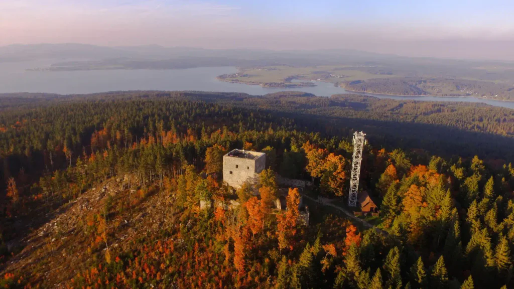 panoramatický pohled na Vítkův hrádek s Lipenskou přehradou a šumavskými kopci a Alpami v pozadí