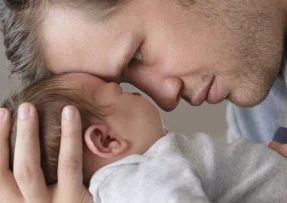 Otec se mazlí s novorozencem