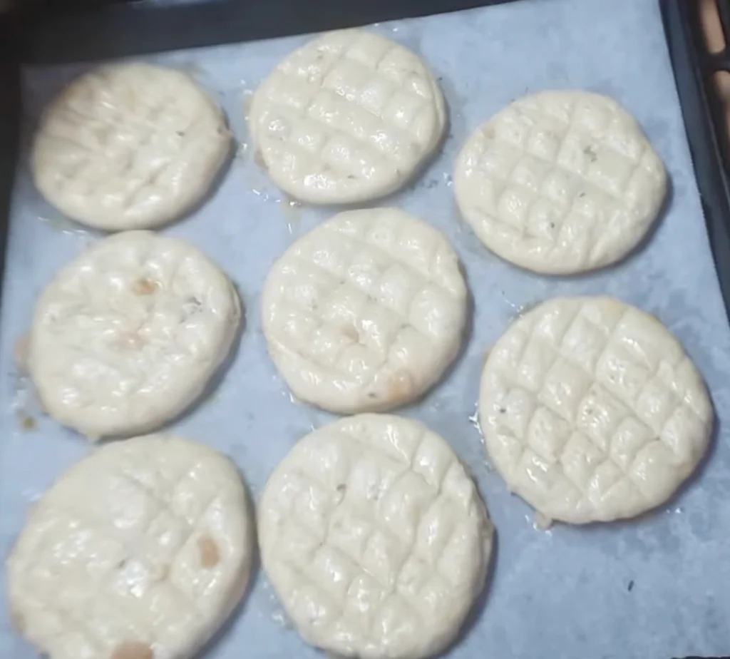 Potřeme vajíčkem a ozdobíme nožem, posypeme kmínem.