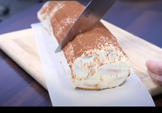 Roládu potřeme zbytkem krému a posypeme kakaem.