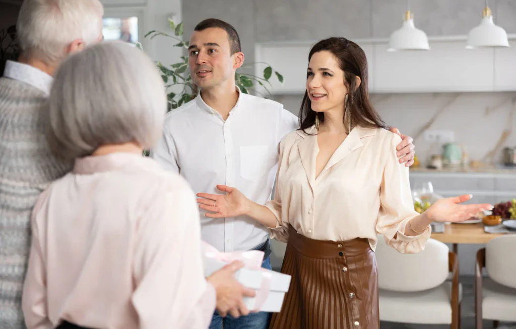 Mladý pár vítající další pár na domácí party.