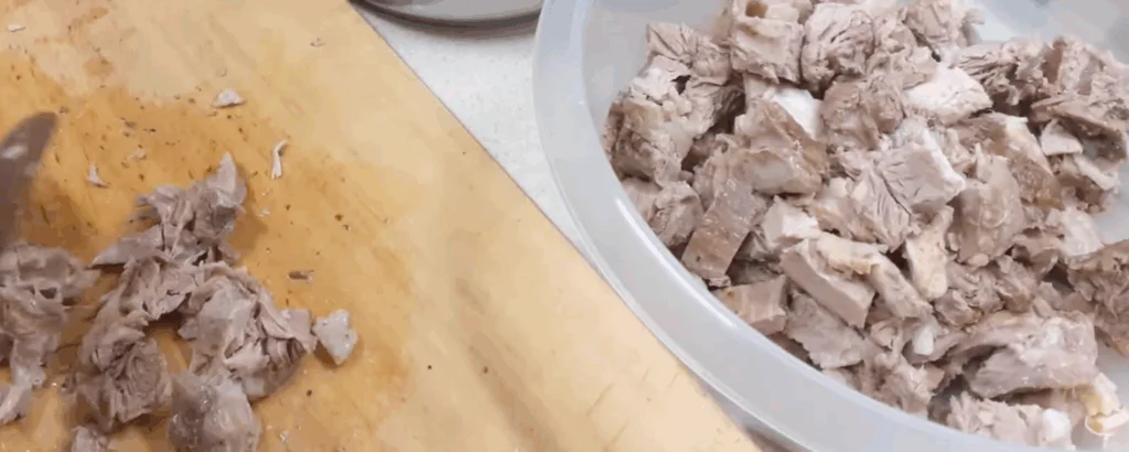 Uvařené maso a kůže nakrájíme.