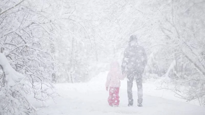 muž s dítětem ve vánici
